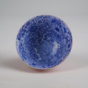 A close-up top-down view of the inside of the Palace Red Elegant Charm Gaiwan cup, highlighting the hand-painted blue and white floral pattern covering the interior.