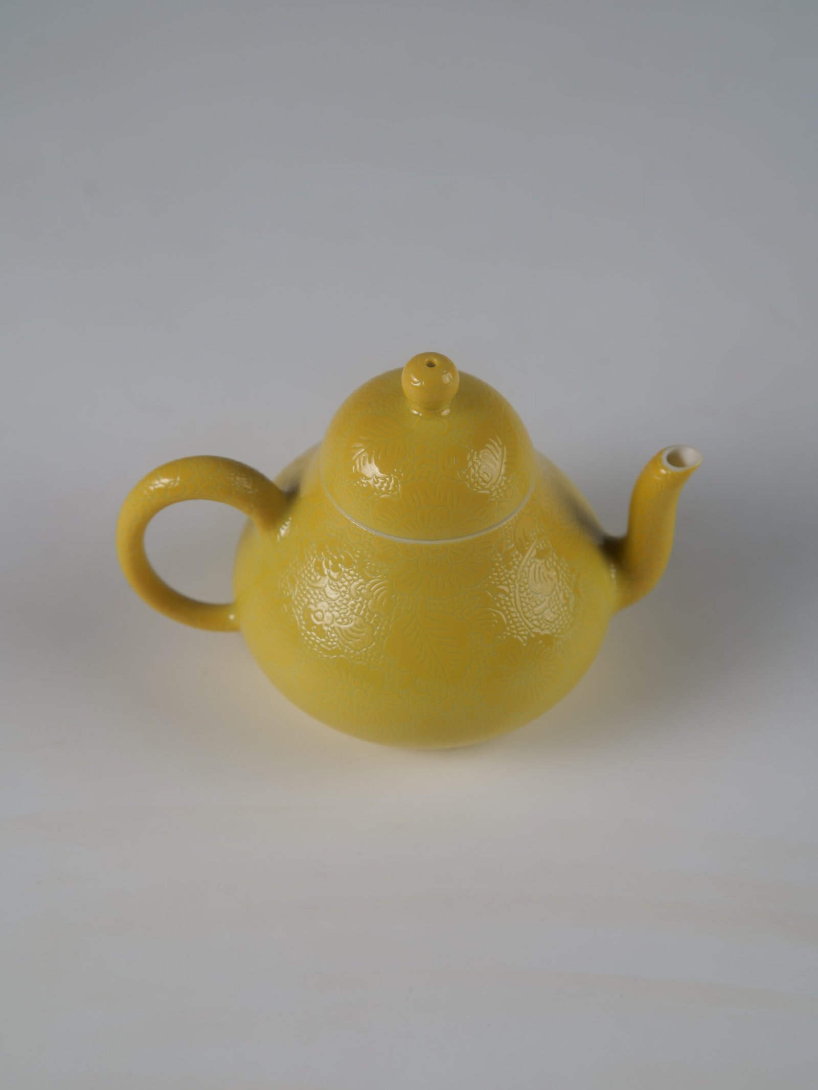 Bright Yellow Pa Hua Pear Teapot – 45 Degree View 45-degree high angle view of bright yellow pear teapot showing intricate Pa Hua hundred flowers pattern