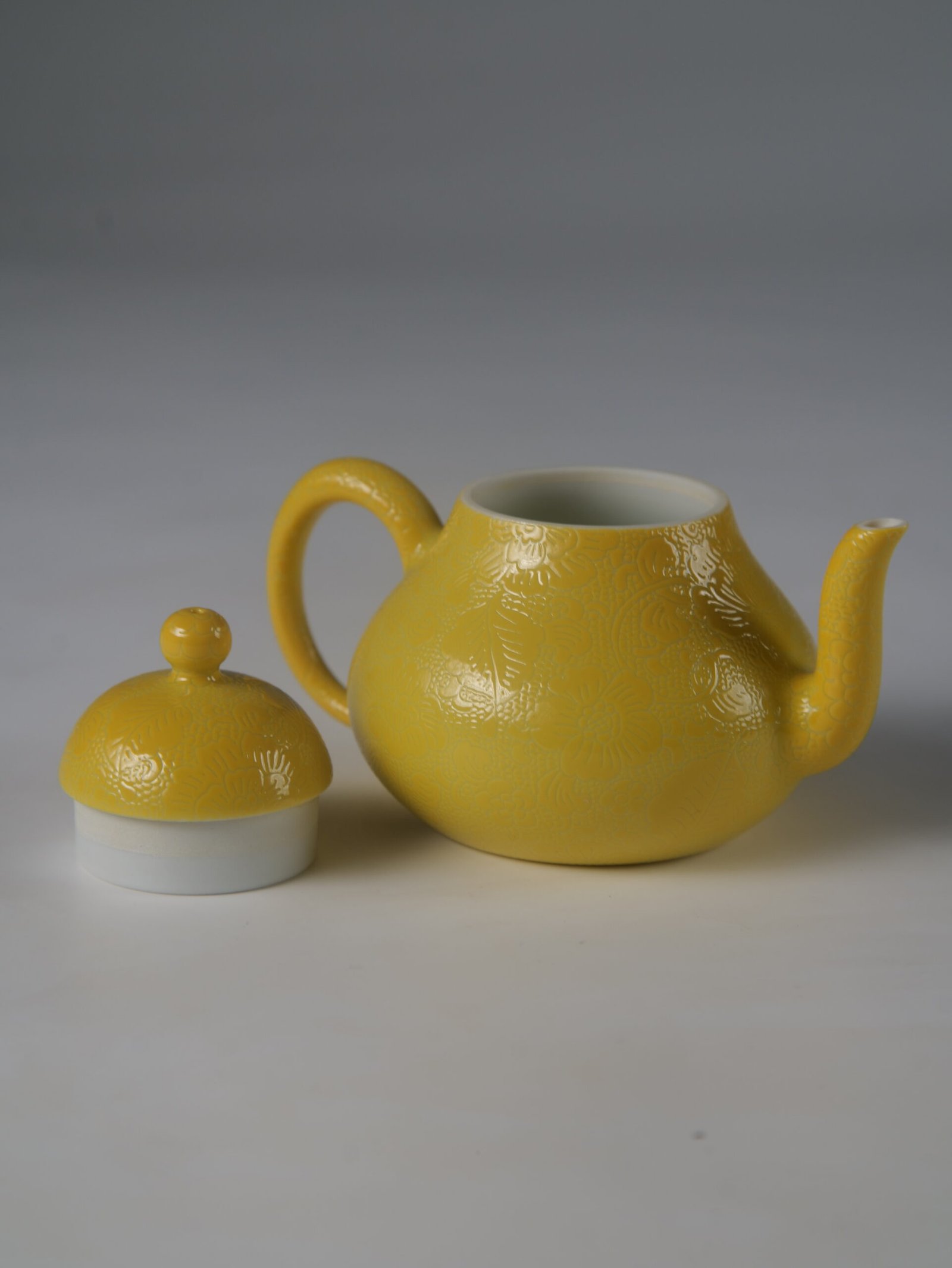 Bright Yellow Pear Teapot – Side View with Lid Off Side view of bright yellow porcelain pear teapot with lid off on white background