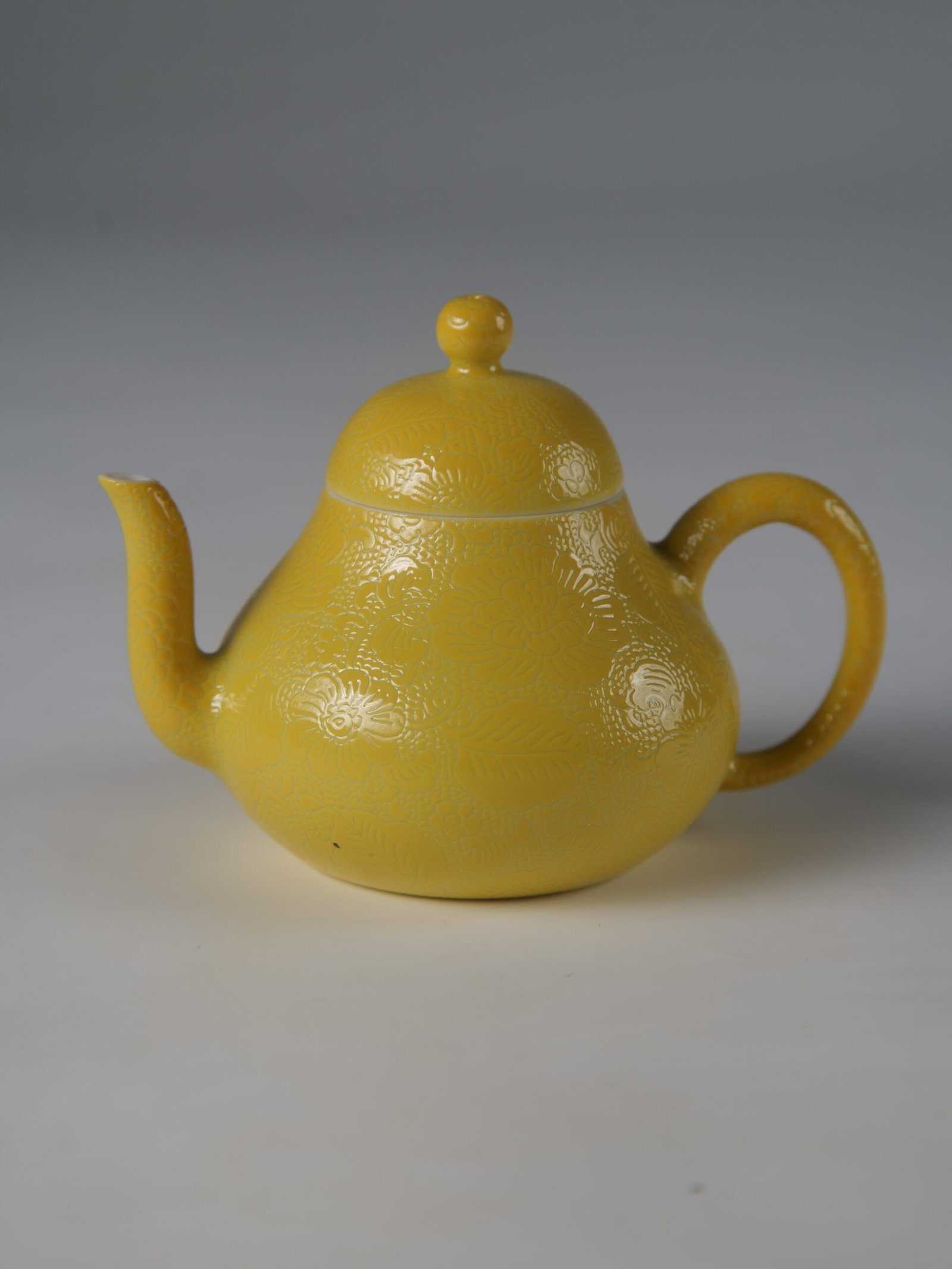 Bright Yellow Pear Teapot – Classic Side Profile Eye-level side profile of bright yellow pear teapot featuring hand-carved hundred flowers Pa Hua pattern
