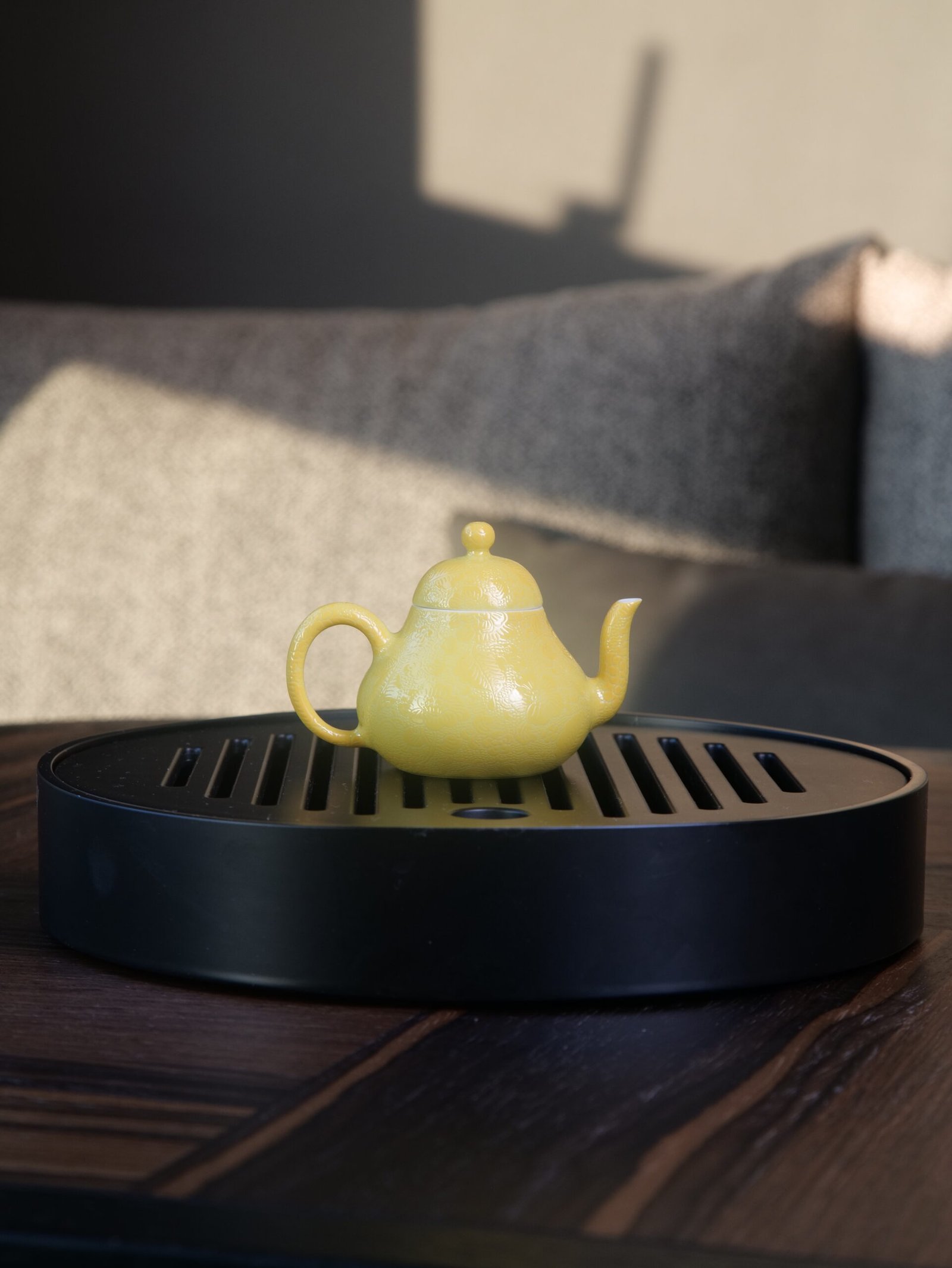 Bright Yellow Pear Teapot - Tea Tray Setting Bright yellow pear teapot with hand-carved hundred flowers pattern placed on a black tea tray in living room setting