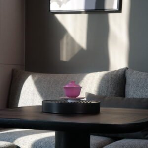 Distant lifestyle view of the Carmine Red Elegant Charm Gaiwan set on a black tea tray in a sunlit modern living room setting