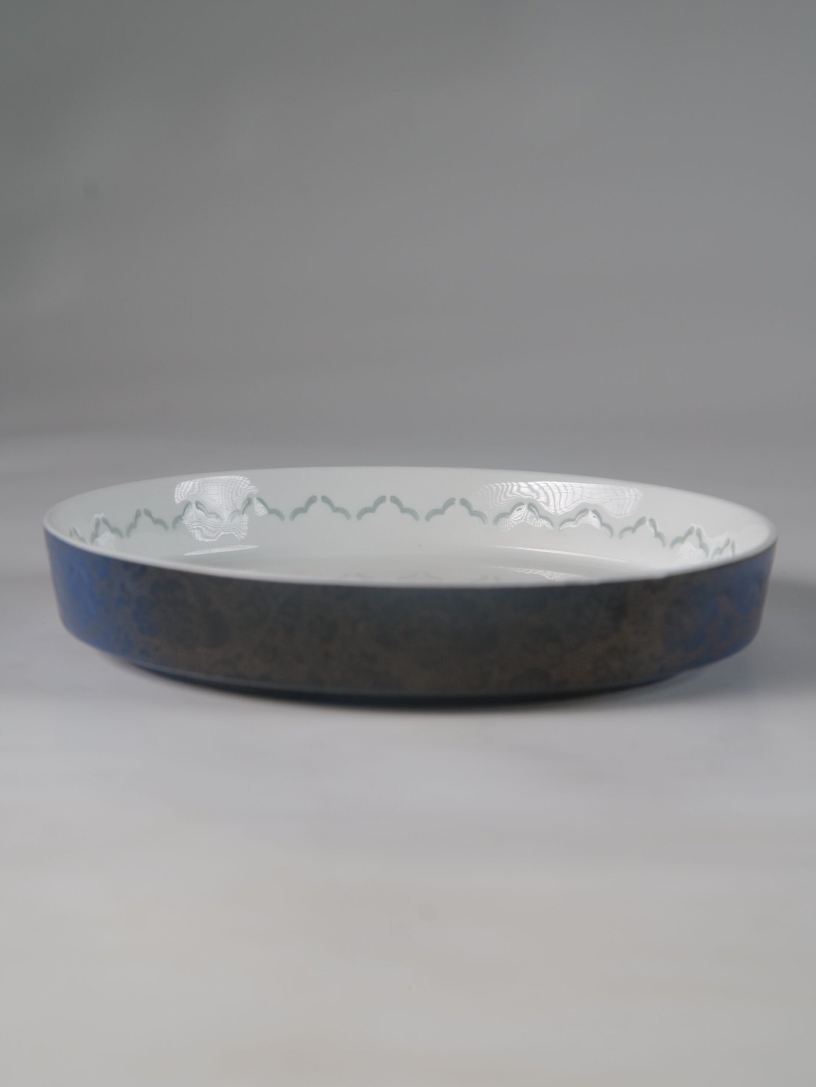 Carved Linglong Porcelain Plate – Side View Side view of round porcelain plate with translucent linglong rim pattern