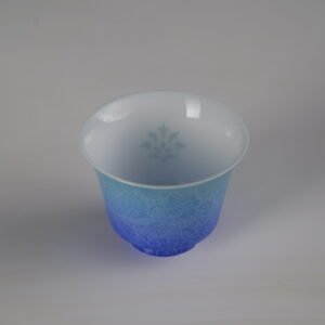 Top-down perspective of the East Breaking Dawn gradient blue porcelain horseshoe cup highlighting the inner subtle pattern and vibrant outer blue gradient
