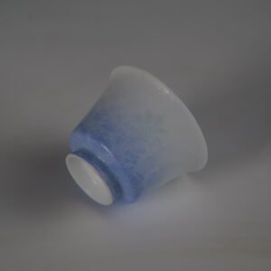 An inverted view of the East Breaking Dawn gradient blue porcelain horseshoe cup showing its refined base and intricate embossed textures
