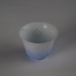 Top-down view of the East Breaking Dawn gradient blue horseshoe porcelain cup showing the smooth rim and translucent interior pattern