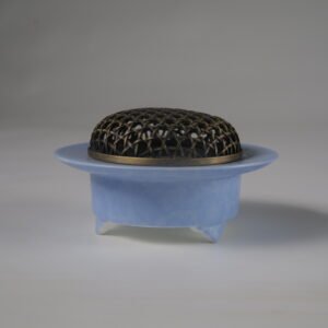 Side view of light blue carved ceramic incense burner with copper lid