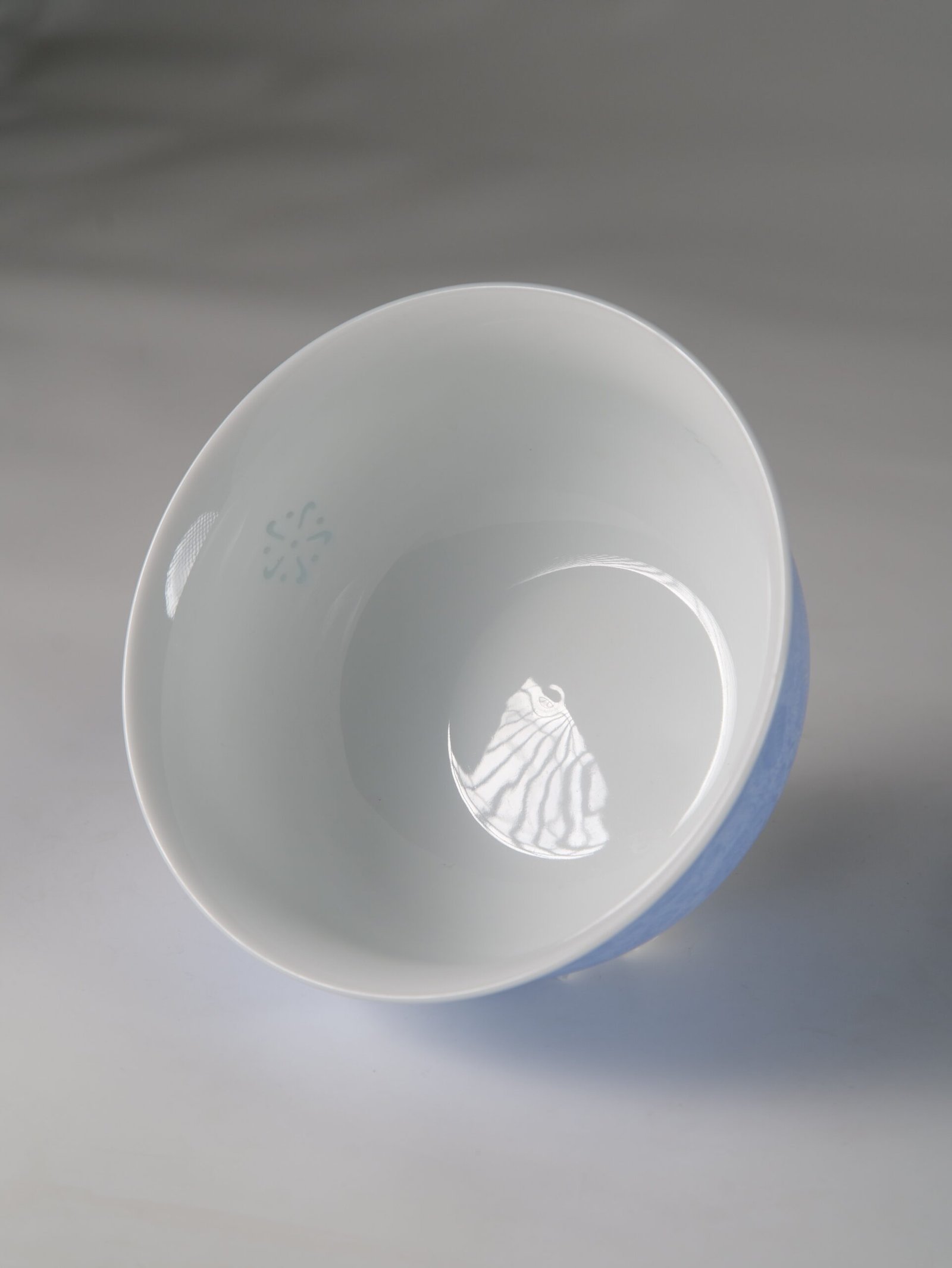 East Breaking Dawn Porcelain Bowl – Translucent Detail Tilted top view of porcelain bowl showing smooth white interior and translucent linglong pattern