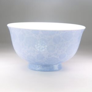 Side view of light blue carved porcelain bowl showing flower pattern