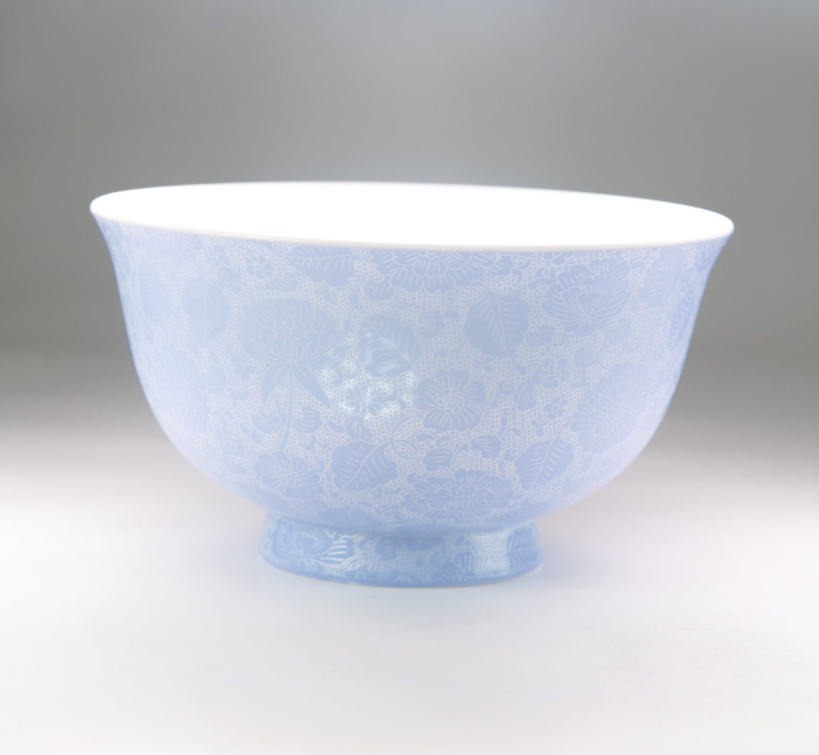 East Breaking Dawn Porcelain Bowl – Side View Side view of light blue carved porcelain bowl showing flower pattern
