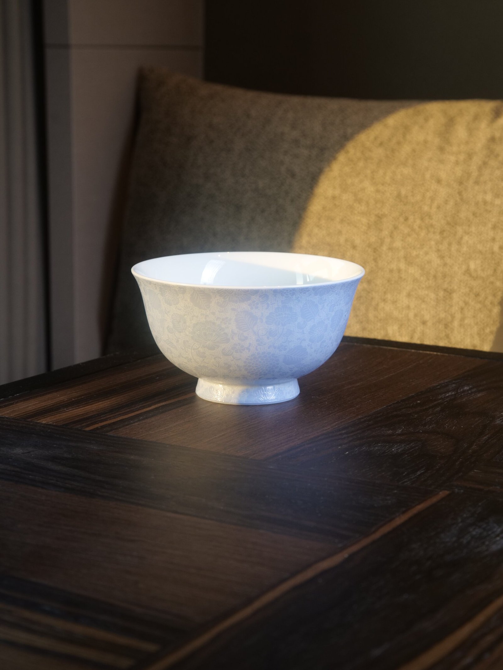 East Breaking Dawn Porcelain Bowl - Interior View Top angled view of light blue porcelain bowl showing white interior on wooden table