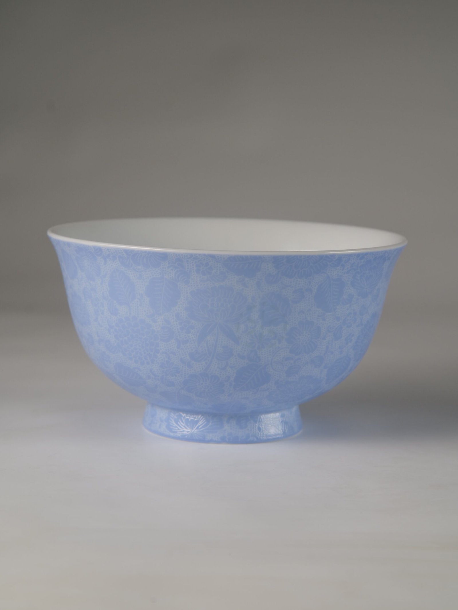 East Breaking Dawn Porcelain Bowl – Studio Profile Front side view of light blue carved porcelain bowl against white background