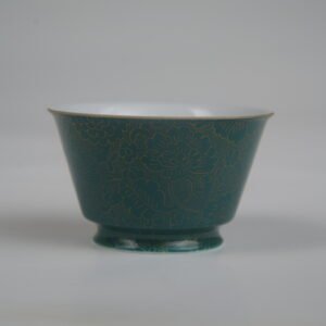 Front profile of the Gold base with blue overlay Linked-loop porcelain cup featuring fine gold rim detailing and carved floral patterns