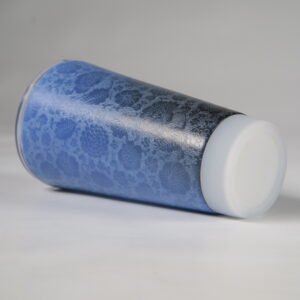 Close up view of carved blue flower pattern on ceramic travel cup