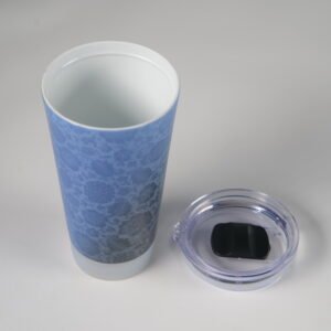 Top angled view showing white interior of blue ceramic cup and clear lid