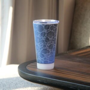 Side view of blue carved ceramic travel mug on dark wooden table