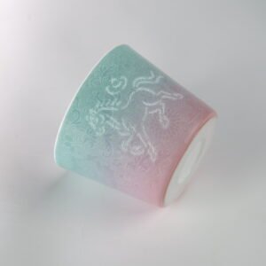 Tilted view of Jingdezhen gradient porcelain cup with hand-carved lotus pattern