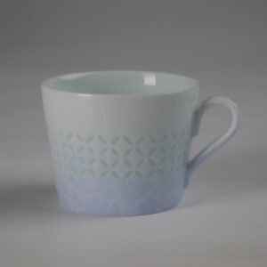 Bright side view of light blue gradient porcelain coffee cup