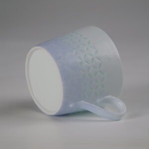 Tilted view of light blue coffee cup showing outer pattern and base