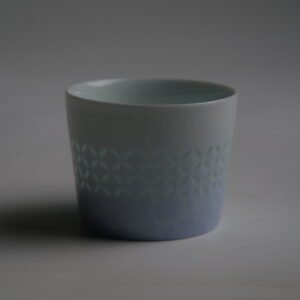Darkened back view of light blue cup showing Linglong coin pattern