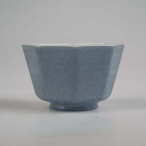 Back view of the Lunar Gray Octagonal porcelain cup displaying its geometric octagonal body, solid lunar gray glaze, and intricate engraved geometric lattice background patterns