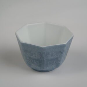 Top-angle front view of the Lunar Gray Octagonal porcelain cup showcasing its geometric octagonal rim, white interior, and solid lunar gray exterior with intricate Shang Dynasty Taotie motif and fine Pa Hua engravings