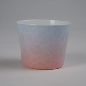 Eye level back view of blue and pink gradient porcelain cup with hundred flowers pattern