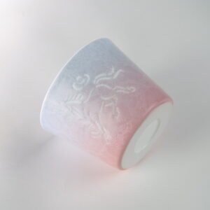 Tilted view of Midsummer Dream pastel gradient porcelain coffee cup with hand-carved hundred flowers pattern