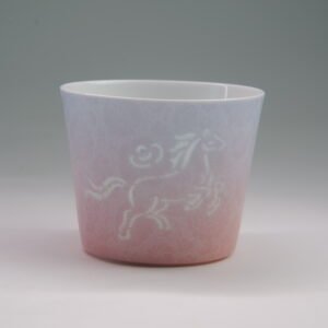 Eye level front view of Midsummer Dream porcelain cup displaying translucent pierced horse pattern