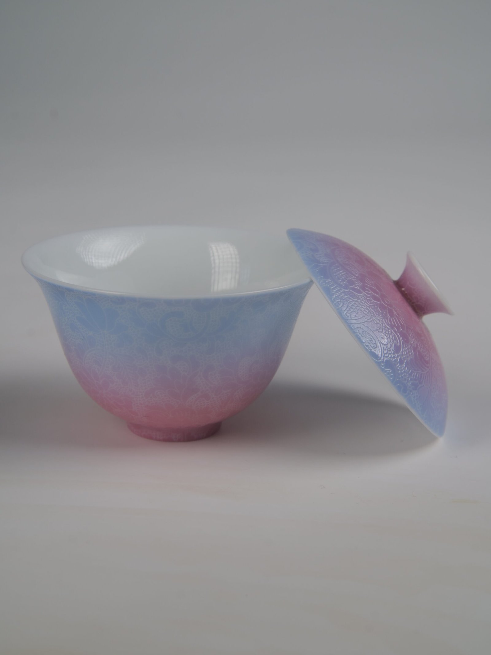 midsummer-dream-gradient-elegant-charm-gaiwan-open-lid-without-saucer-view Side view of the Midsummer Dream Gradient Elegant Charm Gaiwan without saucer, showing the lid resting against the cup, white porcelain interior, soft pale purple and pink gradient glaze, and handcrafted Pa Hua floral pattern