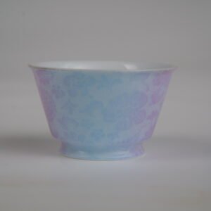 Side view of the Misty Lavender Haze Linked-loop porcelain cup featuring soft pastel blue hues transitioning into lavender with fine carved floral details