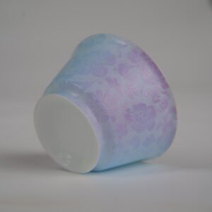 Bottom-up view of the Misty Lavender Haze Linked-loop porcelain cup showcasing its white foot base and pastel blue-and-purple carved floral texture