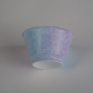 Low-angle perspective of the Misty Lavender Haze Linked-loop porcelain cup, showing its white foot rim and soft pastel purple-to-blue gradient carved floral body