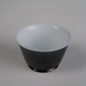 Top-down view of the Obsidian Black Linked-loop porcelain cup featuring a smooth white interior and dark carved dragon scale exterior