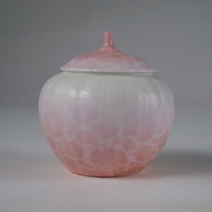 Eye level front view of peach pink gradient melon-shaped jar with hundred flowers pattern