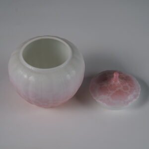 High angle view of open peach pink melon jar showing white glazed interior