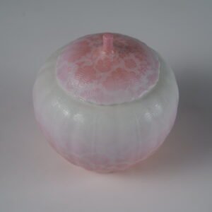Top view of peach pink gradient porcelain melon-shaped jar with lid