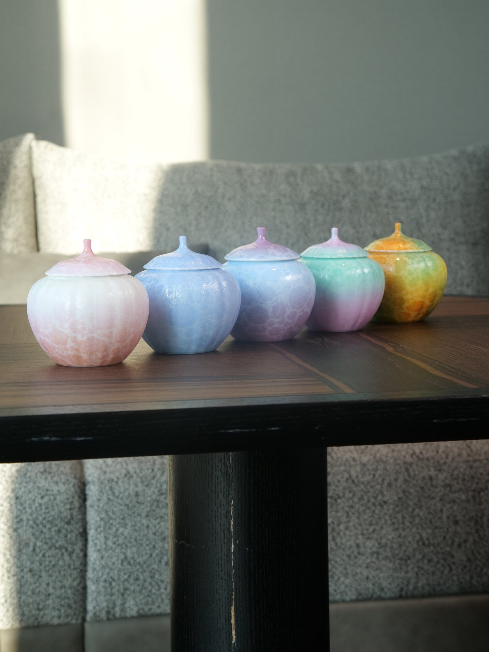 Peach Pink Gradient Melon Jars – Tea Table Display Five colorful gradient porcelain melon jars displayed on a dark wooden tea table