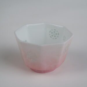 Top-angle view of the Peach Pink Gradient Octagonal Glazed Linglong porcelain cup displaying its octagonal rim, translucent Linglong rice-grain holes inside, and peach pink gradient glaze