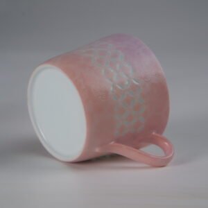 Tilted view of pink coffee cup showing outer pattern and base