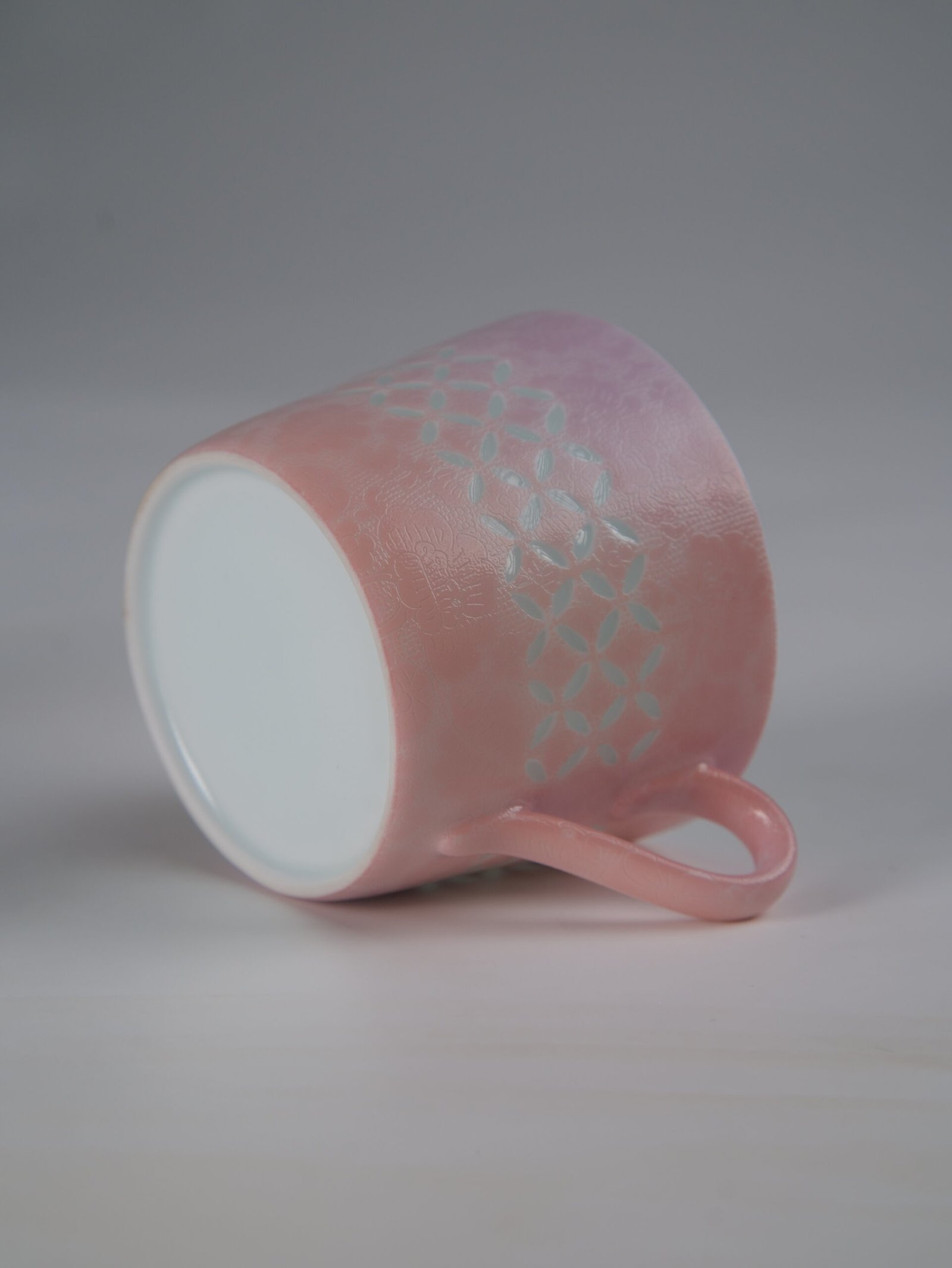 Pink Gradient Coffee Cup – Base View Tilted view of pink coffee cup showing outer pattern and base