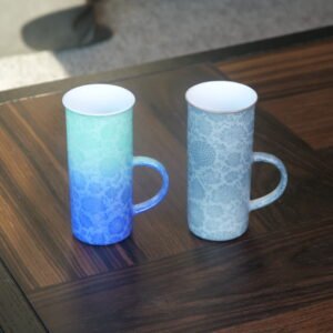 Pair of tall porcelain coffee aroma cups in verdant blue gradient and lunar gray on wooden table
