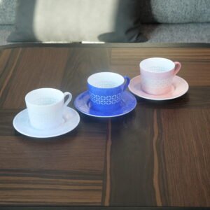 Trio set of porcelain coffee cups with saucers in white ultramarine blue and pink on wooden table