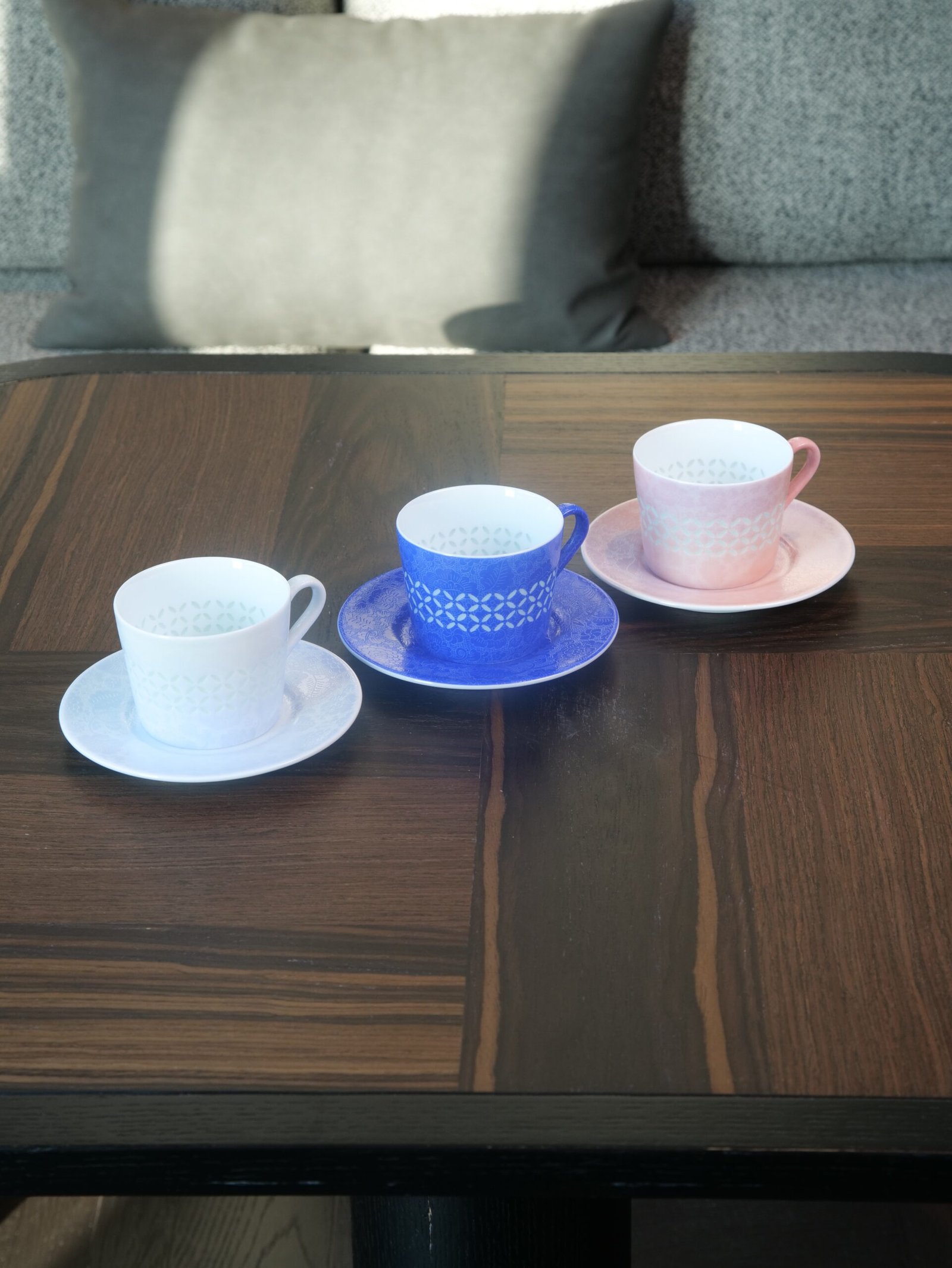 Porcelain Coffee Cup Saucer Sets – Trio Collection Trio set of porcelain coffee cups with saucers in white ultramarine blue and pink on wooden table
