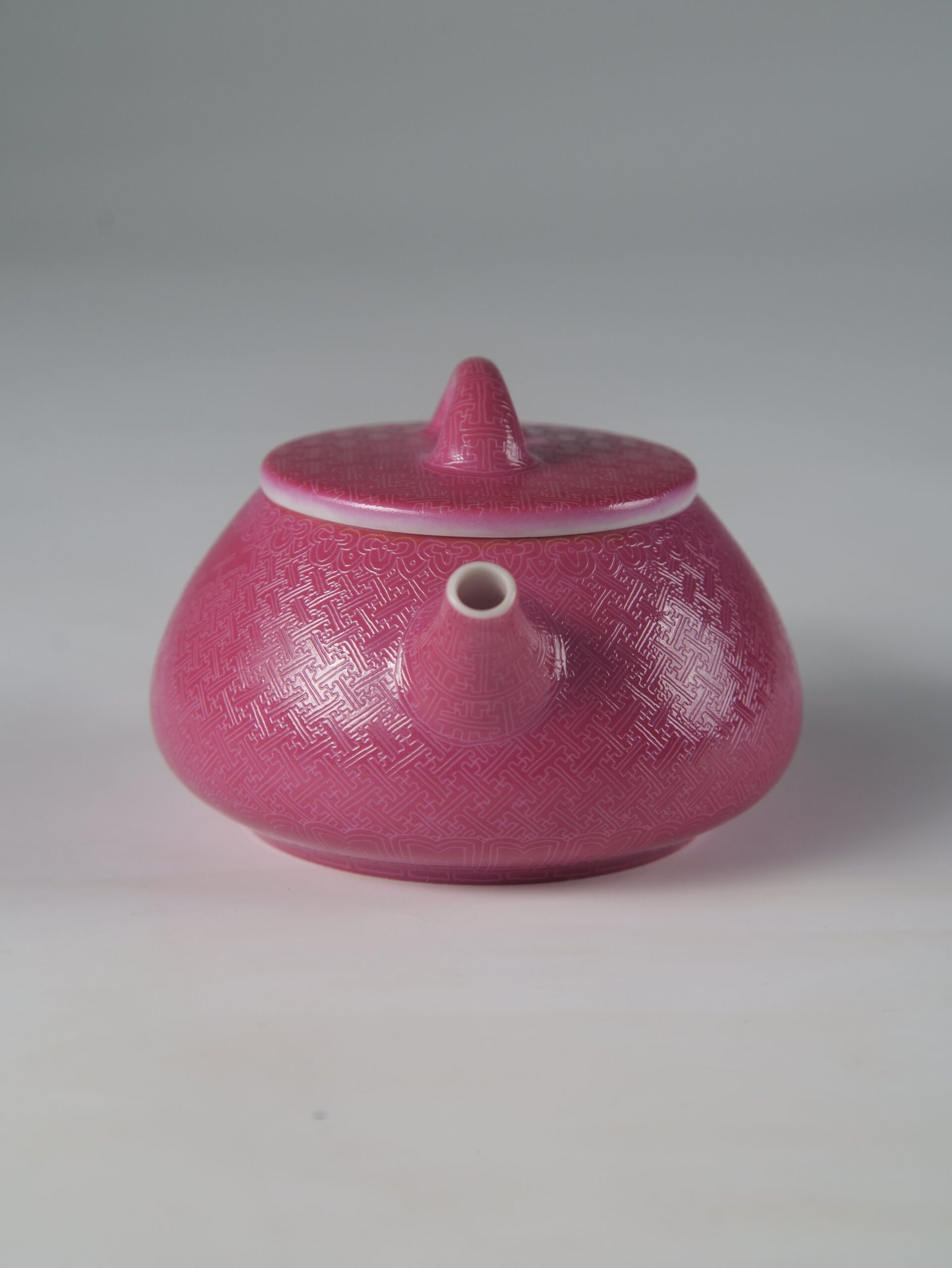 Rouge Red Shi Piao Teapot – Spout Front View Front view facing the spout of a rouge red porcelain Shi Piao teapot with hand-carved Pa Hua details