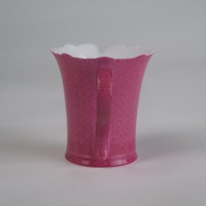 Left perspective high angle view of rouge red flower-rim fair pitcher highlighting the white interior porcelain glaze