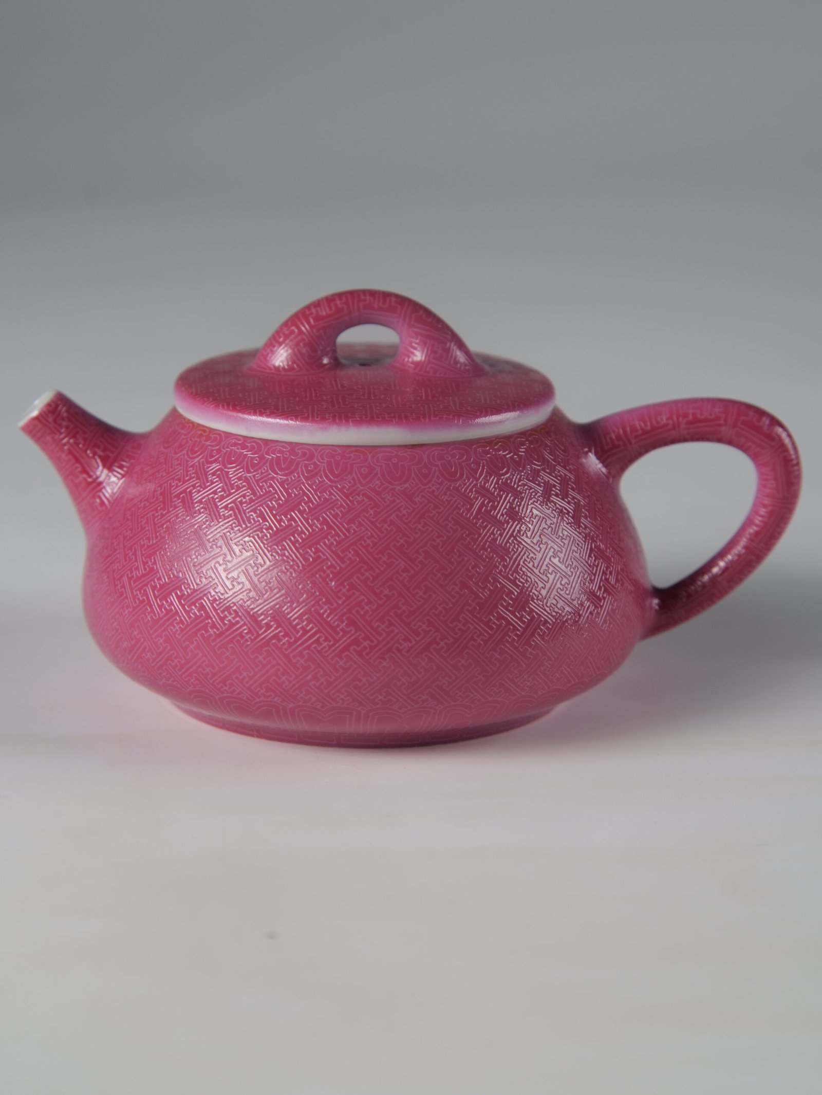 Rouge Red Shi Piao Teapot - Official Side Profile View Side profile view of handcrafted rouge red Shi Piao teapot with symmetrical swastika geometric carving