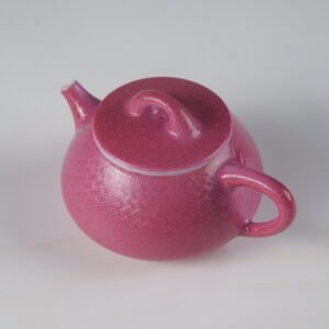 Top angle view of rouge red Shi Piao teapot featuring intricate hand-carved swastika pattern in Pa Hua porcelain