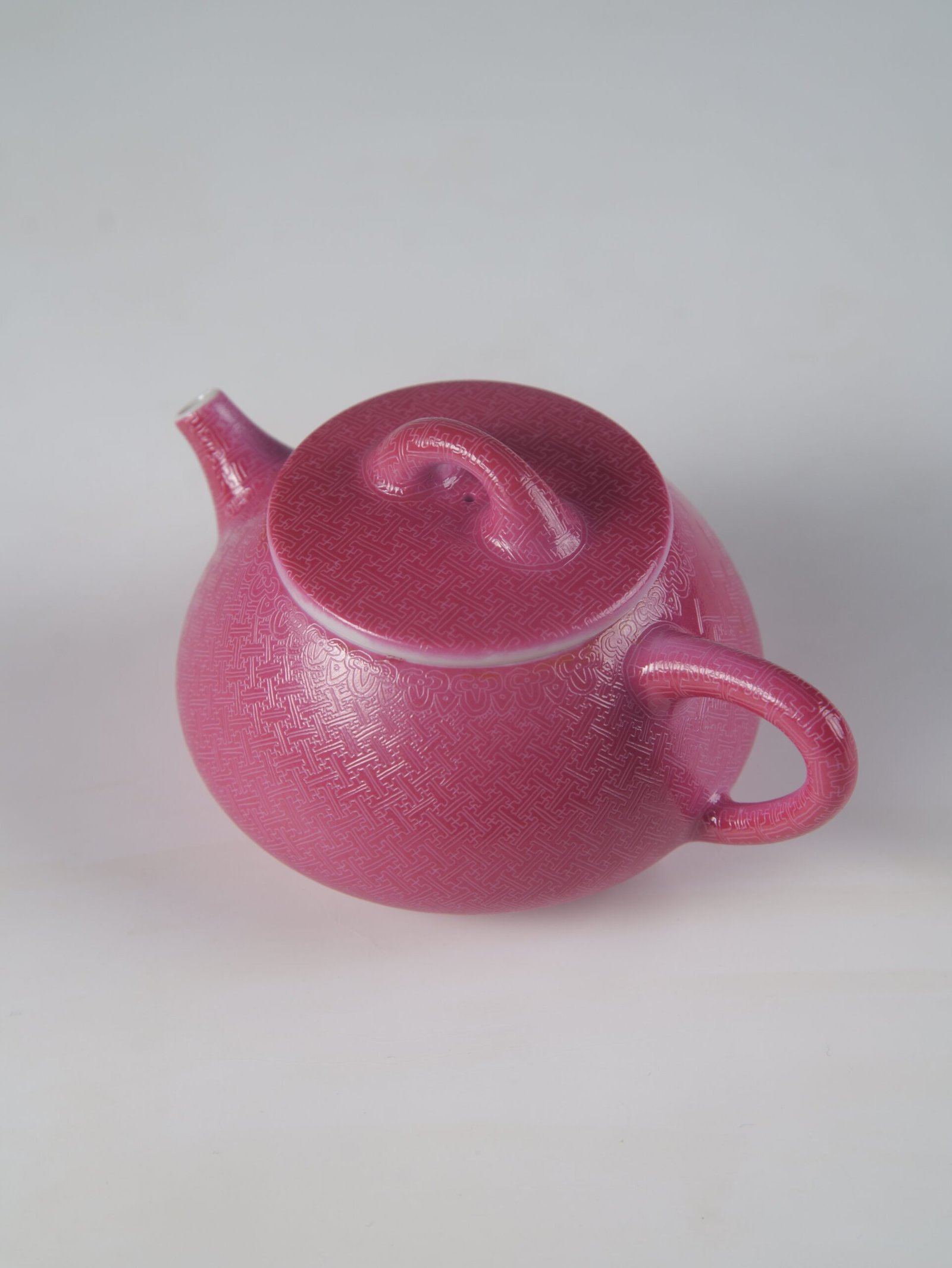 Rouge Red Shi Piao Teapot – Swastika Pattern Detail Top angle view of rouge red Shi Piao teapot featuring intricate hand-carved swastika pattern in Pa Hua porcelain