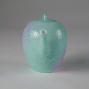 Eye-level front view facing the spout of a spring glow gradient beauty shoulder porcelain teapot on white background